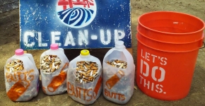 Milk jugs holding collected cigarette butts.