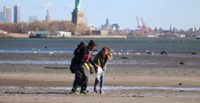 Kids picking up debris on a NYC beach.