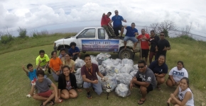 Participants pose with their haul from a beach cleanup as part of the Micronesia Island Nature Alliance’s efforts against marine debris.