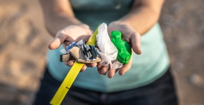 Hands holding out marine debris collected from a lake shoreline.