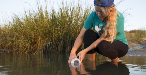 A citizen scientists collects water samples.