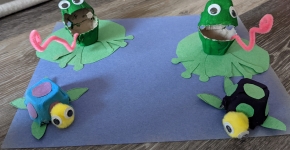 A pond made of blue construction paper with recycled-egg-carton frogs and turtles.