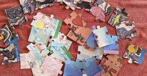 Three different puzzles laid out in pieces on a table.