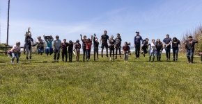Large group of students on a grassy slope.