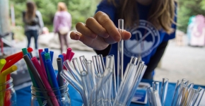 A child picks up a glass straw. 