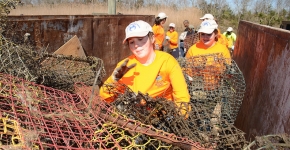 Volunteers fill a container with derelict crab traps collected during a "Derelict Crab Trap Rodeo" in 2014. 