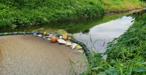 An interception technology device placed in a waterway to capture marine debris.