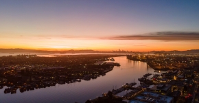 An aerial view of a waterway through an urban area at sunset.