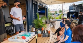 A pair of presenters at a table talking about marine debris to a group.