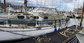 A derelict vessel tied to a dock.