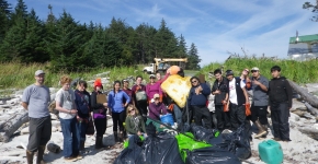 Students gather around several bags of trash. 