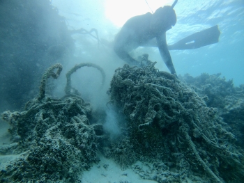 A diver removing a net from the sea floor in Maro Reef. 