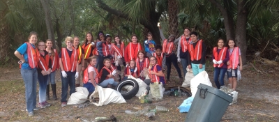 A class in Georgia conducts a cleanup as they stand for a group picture and smile.