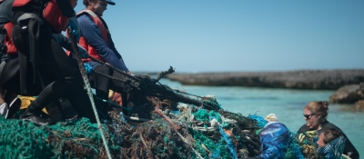 Marine debris removal team pulls a derelict net mass out from the waters of Midway Atoll. 