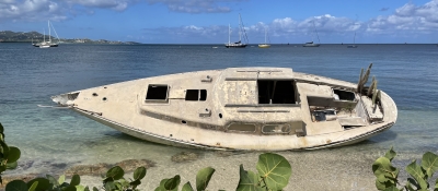 A derelict vessel beached near the shore.