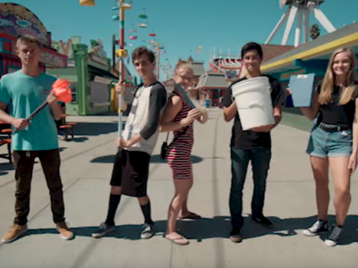 Five teenagers holding different marine debris removal tools such as a clipboard, a bucket, and measurement sticks.