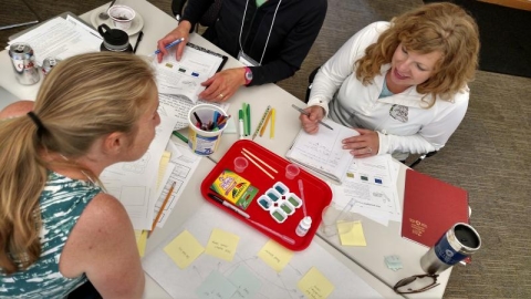 People sitting at desk with multiple activities.