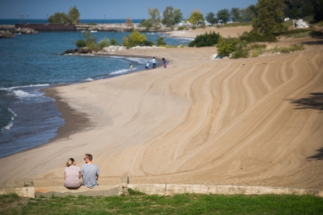 People sitting by a groomed lake shoreline.