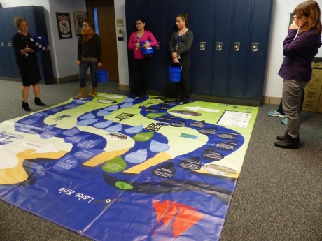 Teachers around a watershed floor mat.