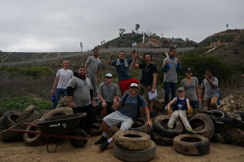 Group of people cheering on top of a pile of tires.